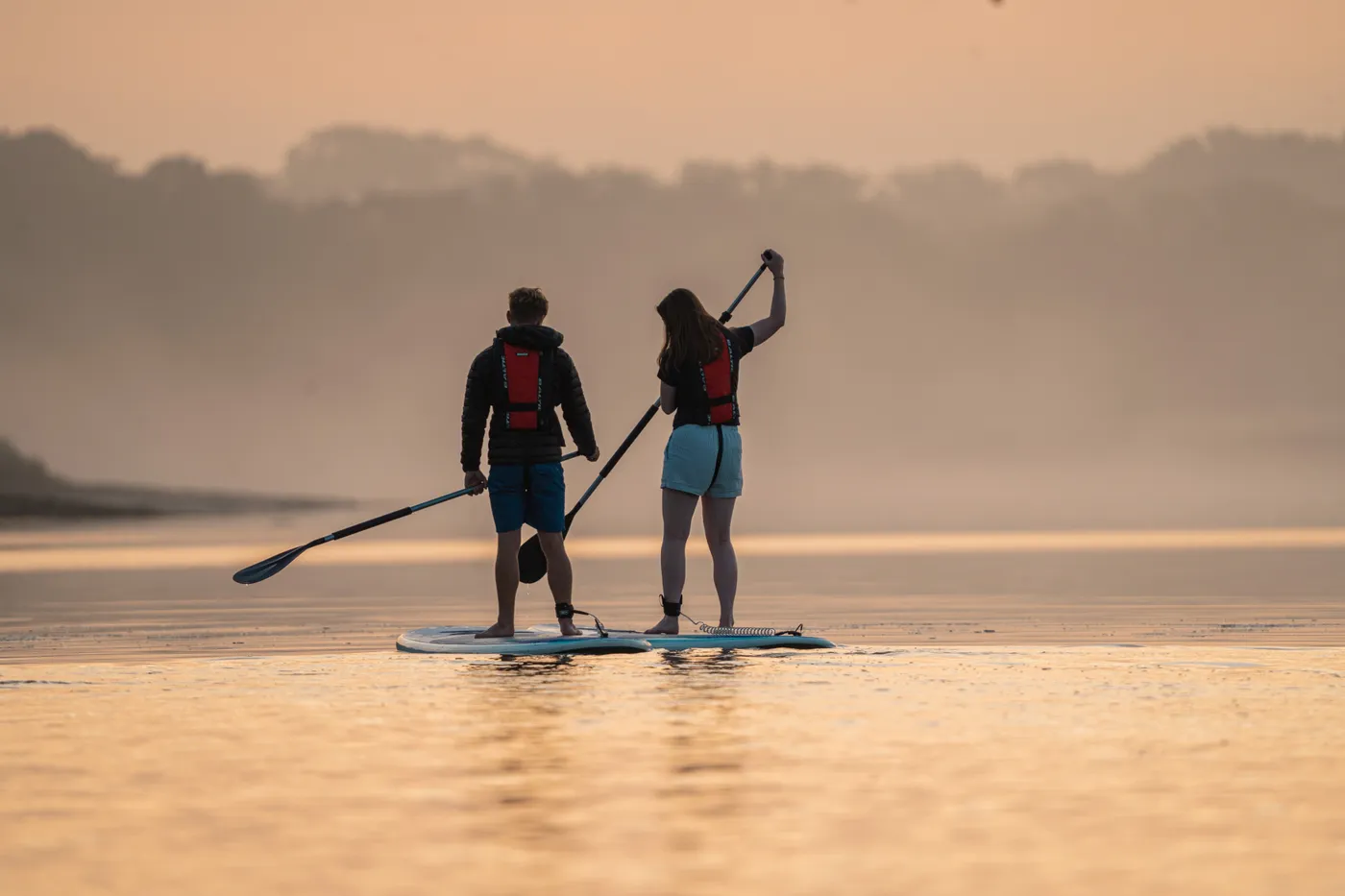 Couple paddling at sunset