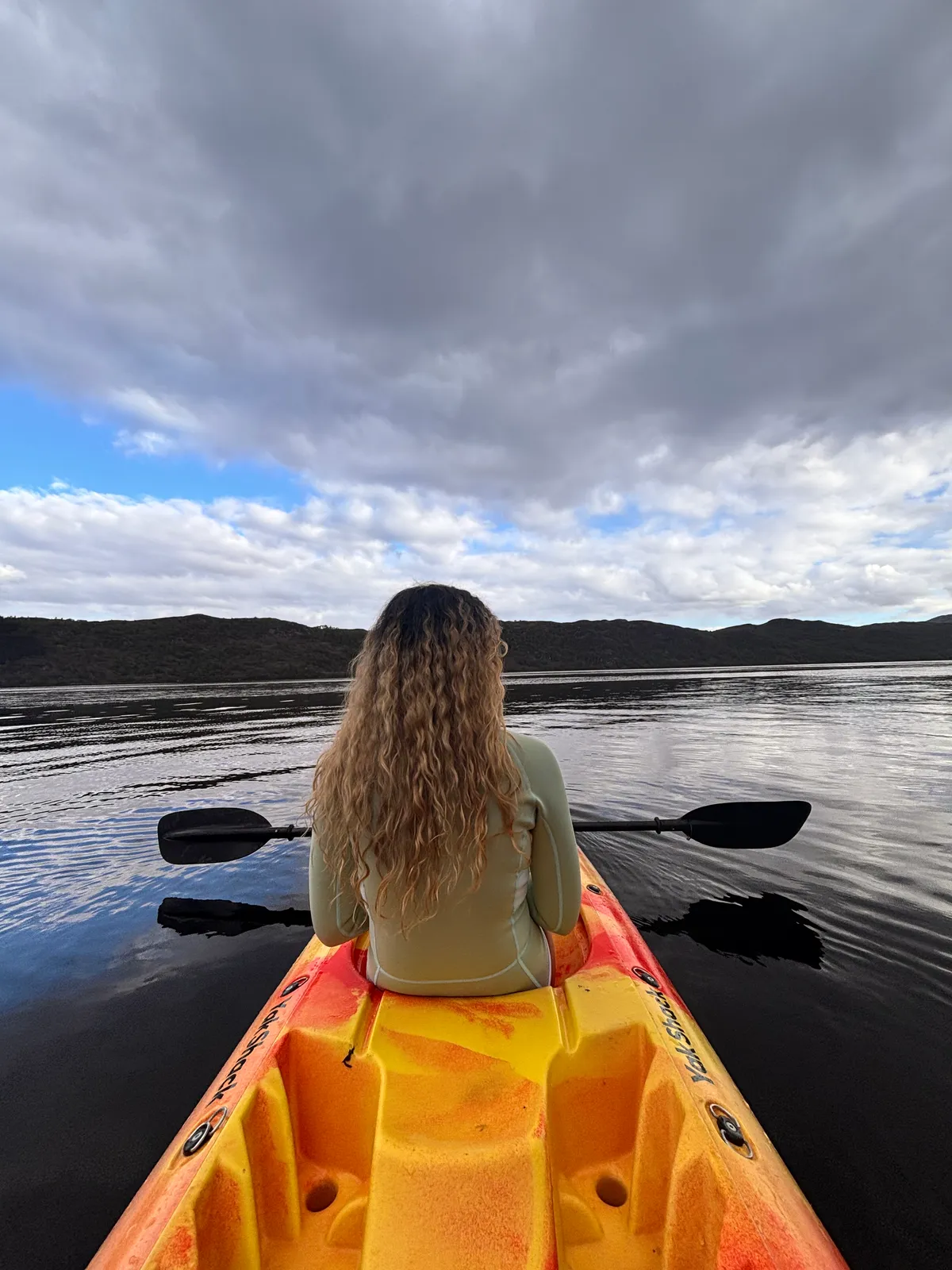Paddler on a Yak Shack kayak looking out across a calm Loch Ness in the Scottish Highlands