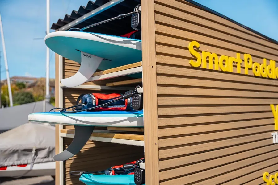 Paddleboards racked at the Yak Shack smart rental station, Shoreham-on-Sea